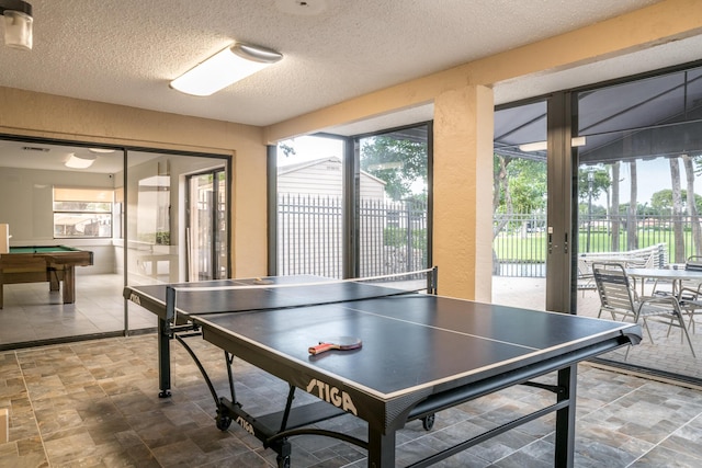 rec room with french doors, pool table, plenty of natural light, and a textured ceiling