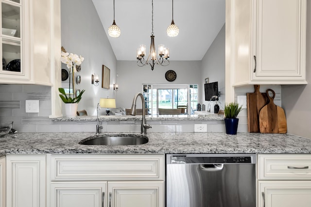 kitchen featuring light stone counters, sink, stainless steel dishwasher, and hanging light fixtures