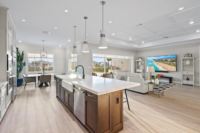 kitchen featuring dishwasher, open floor plan, plenty of natural light, and a kitchen breakfast bar