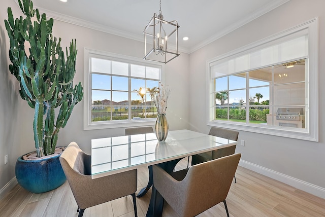 dining area featuring a healthy amount of sunlight, baseboards, crown molding, and wood finished floors