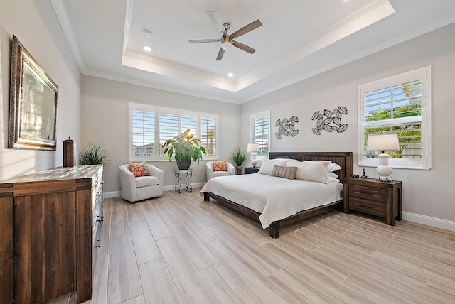 bedroom with baseboards, a tray ceiling, crown molding, and wood finish floors