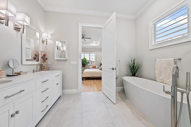 full bathroom featuring double vanity, a freestanding tub, a sink, and crown molding