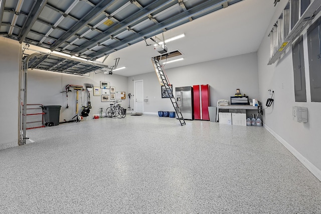 garage featuring a garage door opener, stainless steel fridge, and baseboards