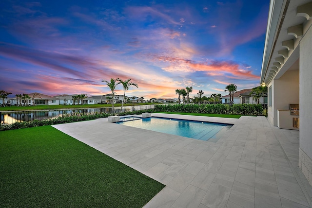 view of swimming pool featuring a fenced in pool, a water view, a lawn, a patio area, and a residential view