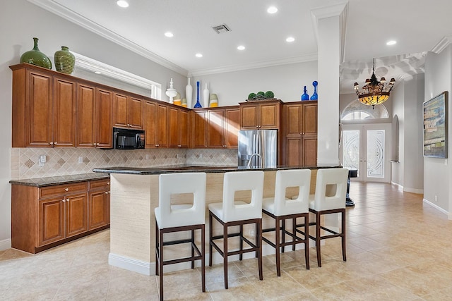 kitchen with stainless steel refrigerator with ice dispenser, a kitchen island, ornamental molding, and a breakfast bar area