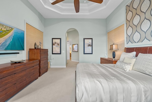 carpeted bedroom featuring crown molding, a towering ceiling, ceiling fan, and a tray ceiling