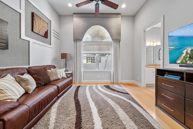 living room with ceiling fan and light hardwood / wood-style flooring