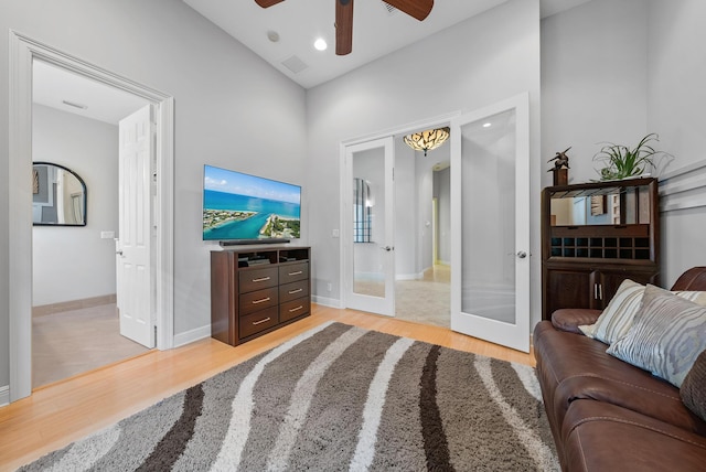 living room with french doors, ceiling fan, and light hardwood / wood-style flooring