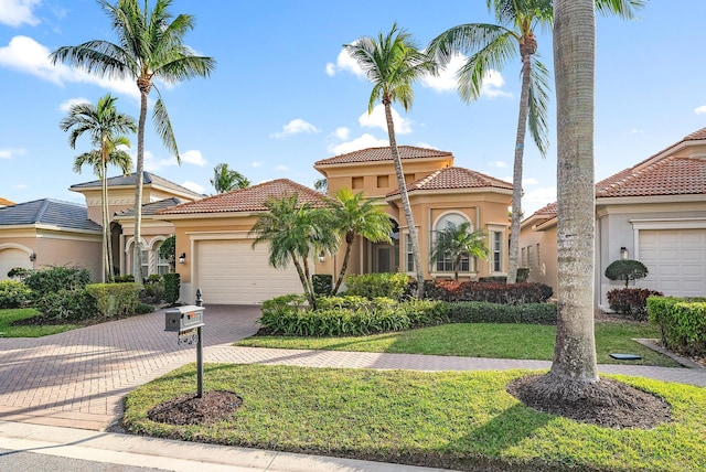 mediterranean / spanish-style home with a garage and a front lawn