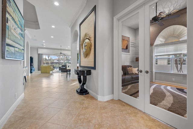 hallway with ornamental molding, light tile patterned flooring, and french doors