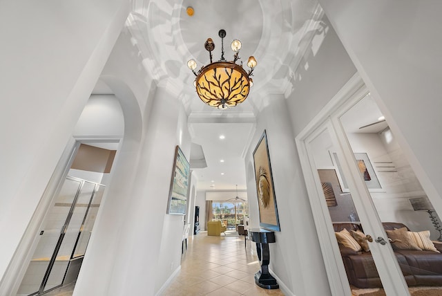 hall with light tile patterned floors, a notable chandelier, and french doors