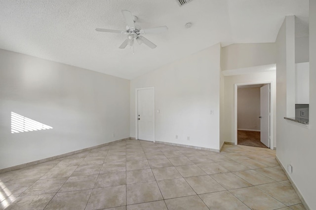 unfurnished room featuring light tile patterned flooring, ceiling fan, lofted ceiling, and a textured ceiling