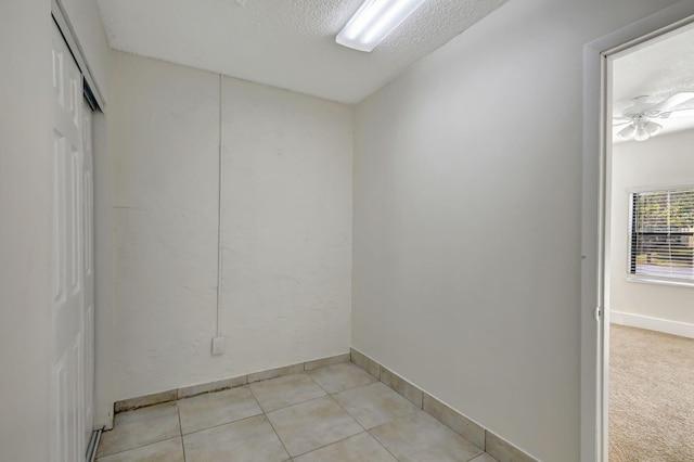 tiled spare room featuring a textured ceiling