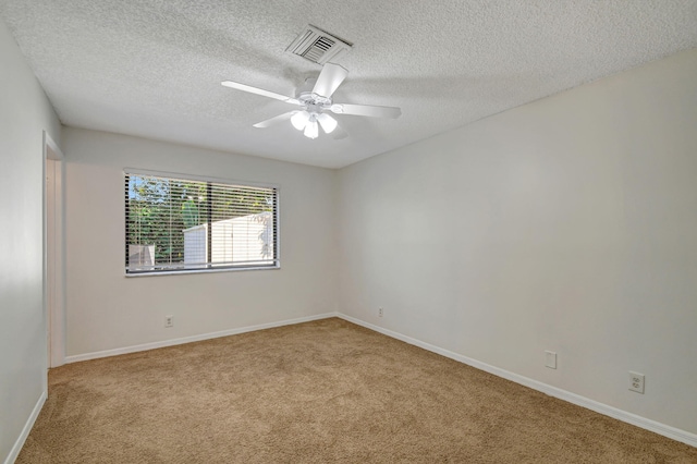 carpeted empty room featuring a textured ceiling and ceiling fan