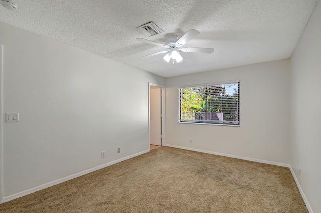 carpeted spare room featuring a textured ceiling and ceiling fan