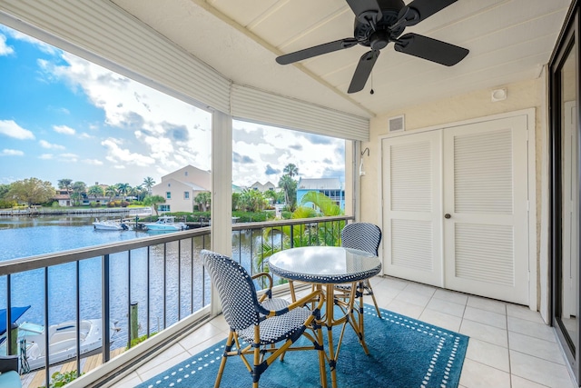 sunroom / solarium with a water view, lofted ceiling, and ceiling fan