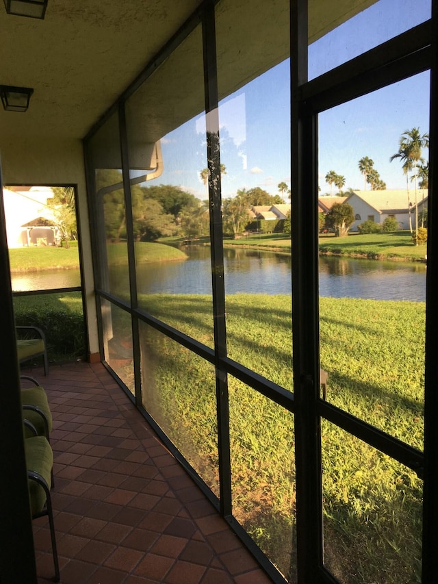 sunroom / solarium with a water view and plenty of natural light