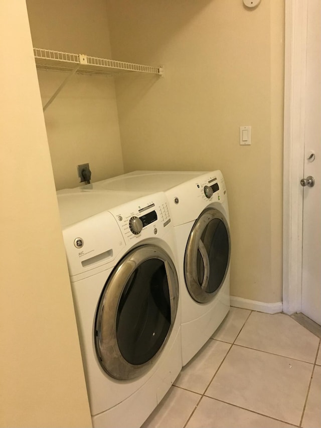 washroom with washing machine and dryer and light tile patterned flooring