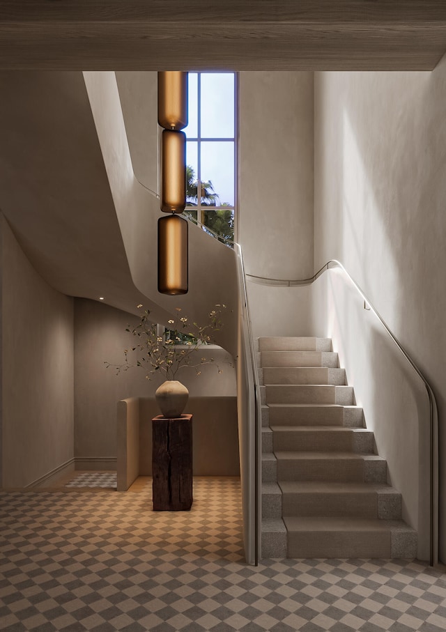 stairs with a towering ceiling and carpet flooring