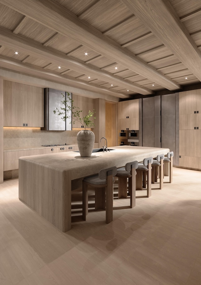 bar with beam ceiling, light brown cabinetry, and sink