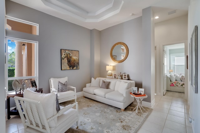 tiled living room featuring a tray ceiling