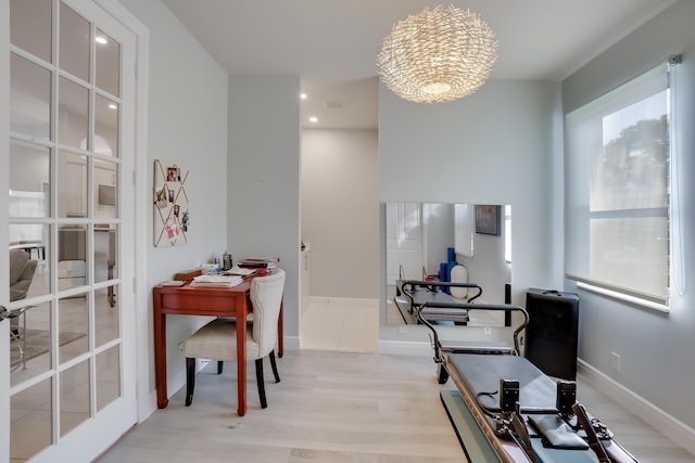 home office with a notable chandelier and light wood-type flooring