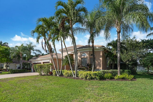 mediterranean / spanish house with a garage and a front lawn