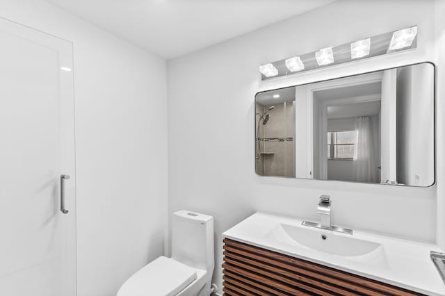 bathroom featuring vanity, a shower, and toilet