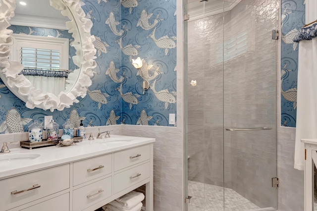 bathroom with an enclosed shower, vanity, ornamental molding, and tile walls