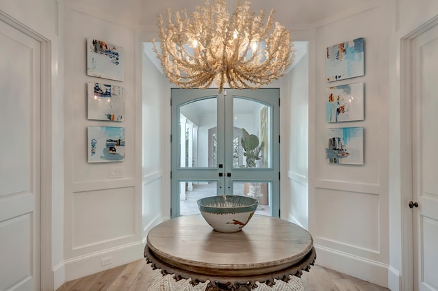 dining room with french doors, a chandelier, and light wood-type flooring