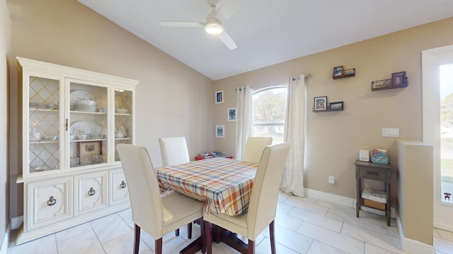 dining room with ceiling fan, lofted ceiling, and light tile patterned floors