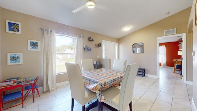 tiled dining space with lofted ceiling and ceiling fan