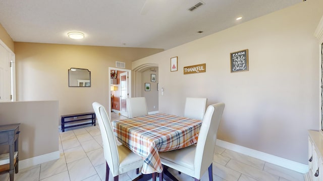 tiled dining space with lofted ceiling