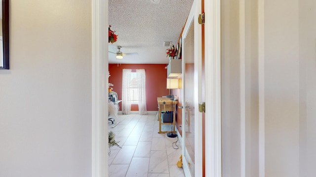 corridor featuring light tile patterned floors and a textured ceiling