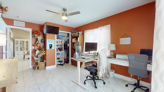 office space featuring ceiling fan and a textured ceiling