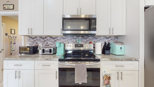 kitchen featuring light stone countertops, white cabinets, and appliances with stainless steel finishes