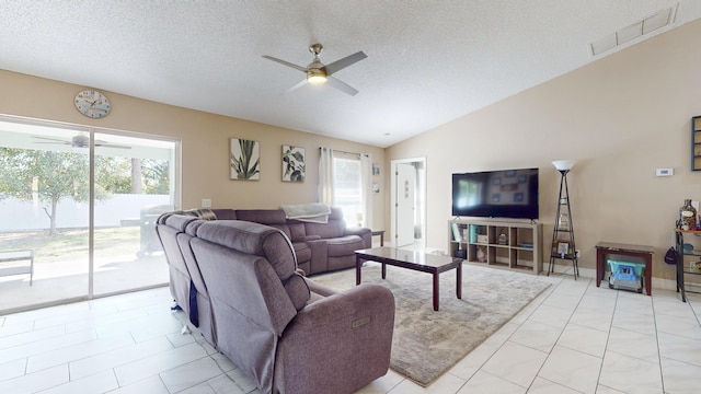 tiled living room with ceiling fan, lofted ceiling, and a textured ceiling