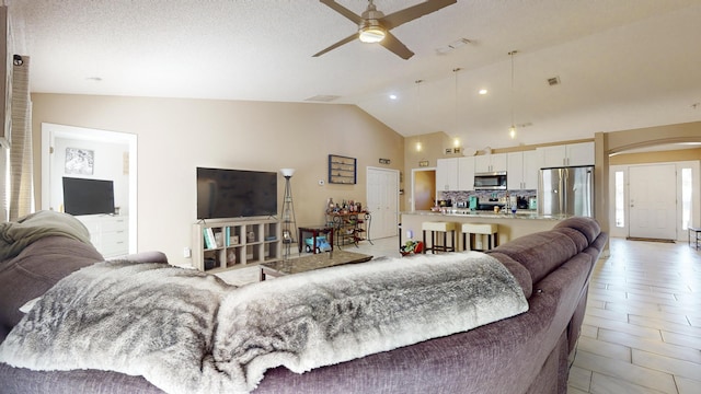 living room with high vaulted ceiling, a textured ceiling, and ceiling fan