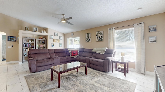 tiled living room featuring ceiling fan, vaulted ceiling, and a textured ceiling