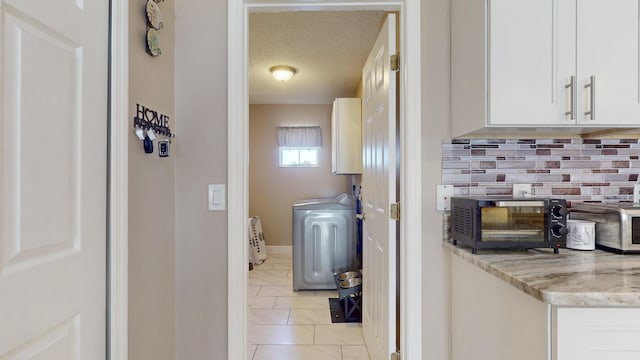 interior space with tile patterned flooring, a textured ceiling, and decorative backsplash