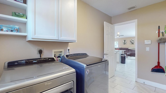 laundry room featuring cabinets and washer and dryer