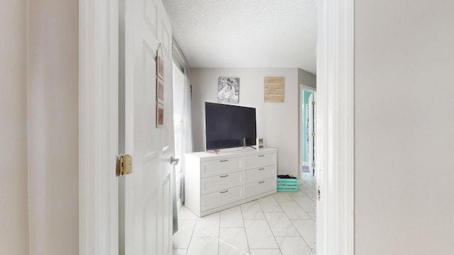 tiled bedroom featuring multiple windows and a textured ceiling