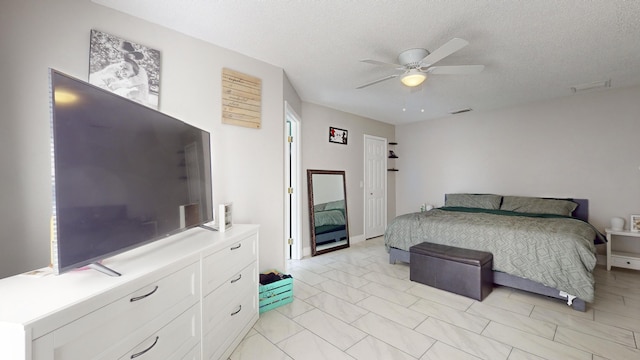 bedroom featuring ceiling fan and a textured ceiling