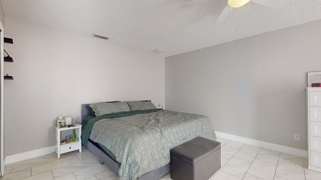 bedroom with ceiling fan and a textured ceiling