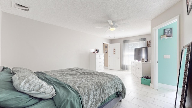 bedroom with ceiling fan and a textured ceiling