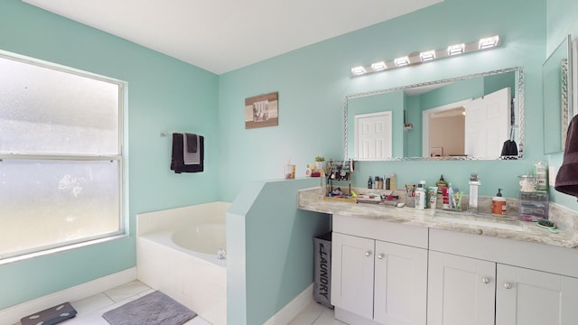 bathroom with a washtub, vanity, and tile patterned floors