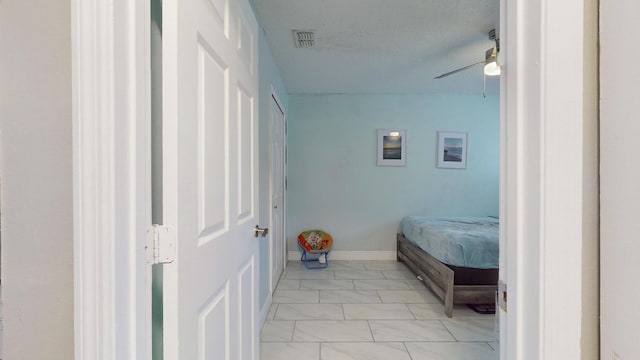 bedroom with ceiling fan and a textured ceiling