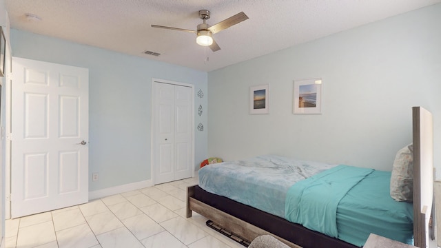 bedroom with ceiling fan, a textured ceiling, and a closet