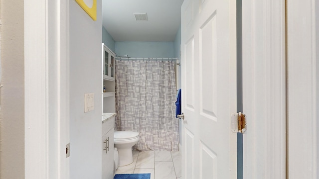 bathroom with walk in shower, vanity, toilet, and tile patterned flooring