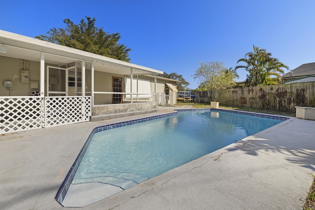 view of swimming pool with a patio area and a sunroom